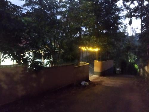 a backyard at night with a fence and trees at PEARL HUT home stay vythiri Wayanad in Vythiri