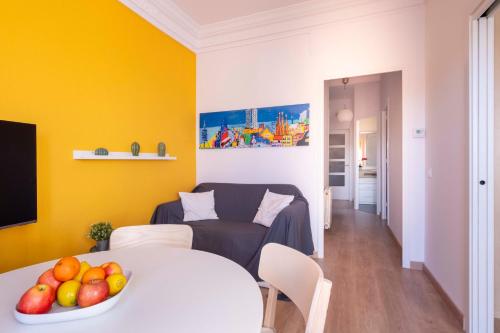 una sala de estar con una mesa con un bol de fruta en Sunny Apt Barcelona 22@, en Barcelona