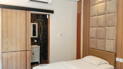 a small bedroom with a bed and a bathroom at Mahestu Hotel in Kuta