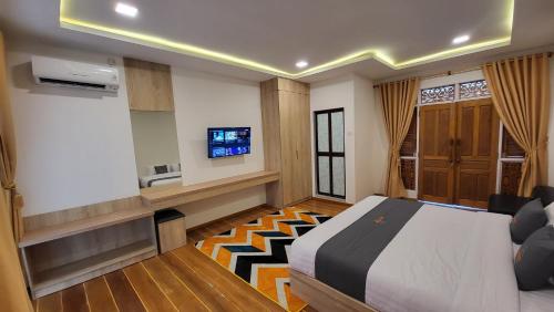 Cette chambre comprend un lit et une télévision. dans l'établissement Kelong Pancing Madu Tiga, à Tanjung Pinang
