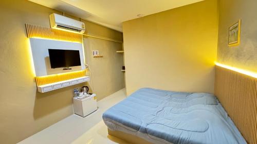 Habitación hospitalaria con cama y TV en มาชิลล์ รีสอร์ท สังขละบุรี en Sangkhla Buri