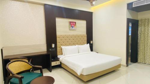 a bedroom with a bed and a chair in it at 7 Hills Hotel & Resort in Nalanda