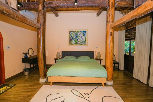 a bedroom with a bed in a room with wooden beams at Bavi Hideaway Retreat - Venuestay in Ba Vì