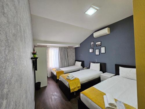 a hotel room with two beds and a window at Cityland Hotel Baku in Baku