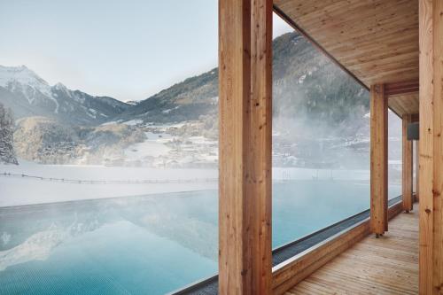 a view of a pool from a house with a mountain at Gut Stiluppe - 4 Sterne Superior Good Life Hotel in Mayrhofen