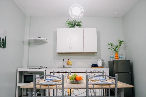 a kitchen with a table with a bowl of fruit on it at Near Airport Transient Inn - 2 Bedroom Suite in Puerto Princesa City