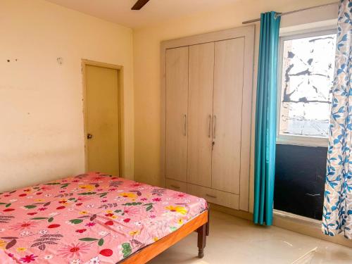 Schlafzimmer mit einem Bett, einem Fenster und einem Schrank in der Unterkunft Friend's Place in Greater Noida