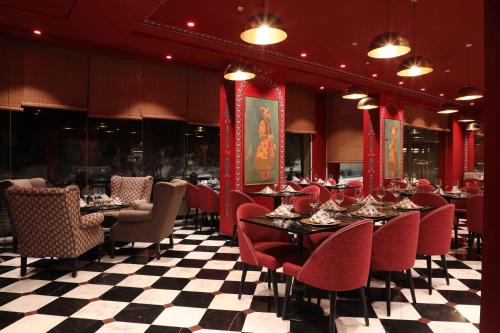 un restaurante con mesas y sillas y suelo a cuadros en Warwick Palm Beach Hotel, en Beirut