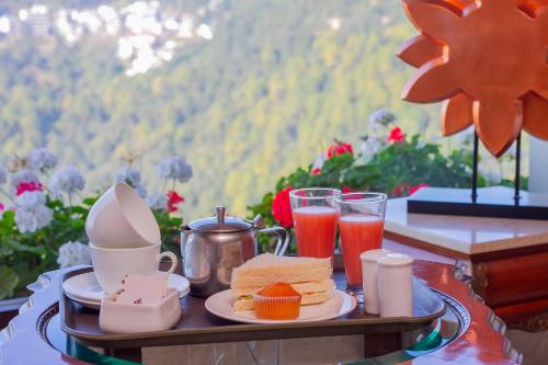 a tray with breakfast foods and drinks on a table at Amritara Surya, Mcleodganj, Dharamshala in Dharamshala