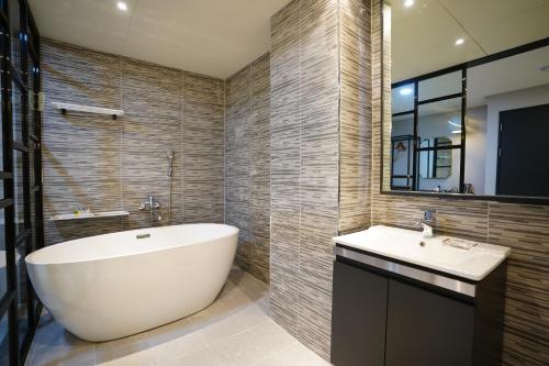 La salle de bains est pourvue d'une baignoire blanche et d'un lavabo. dans l'établissement Dongdaemun Saturn Hotel, à Séoul