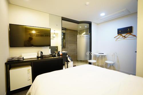 a bedroom with a bed and a tv in a room at Dongdaemun Saturn Hotel in Seoul