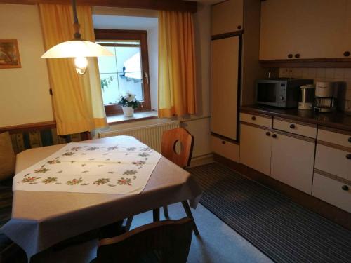 eine kleine Küche mit einem Tisch und einem Fenster in der Unterkunft Apartment Jerzens 1 in Jerzens