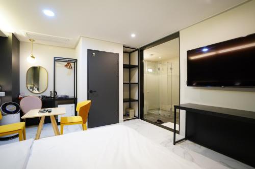 a hotel room with a bed and a flat screen tv at Dongdaemun Saturn Hotel in Seoul