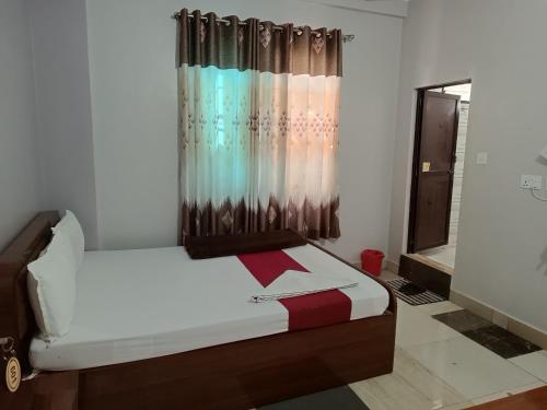 a bed in a room with a curtain at Hotel Ozone 24 in Butwāl