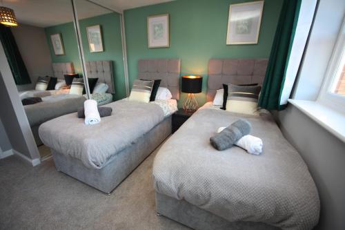 three beds in a room with green walls at Oxford's Most Stylish House - Garden & Parking in Oxford