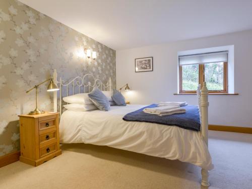 a bedroom with a bed with a blue blanket at Hoppers Barn in Holsworthy