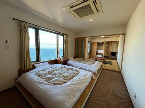 a bedroom with two beds and a large window at LiVEMAX RESORT Shiretoko Sea Front in Rausu