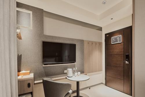 a small room with a table and a television at Orange Hotel -Hanzhong, Taipei in Taipei