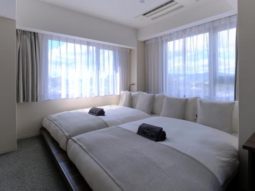 京都市にあるサクラクロスホテル京都清水のベッドルーム1室(窓の前に大型ベッド2台付)