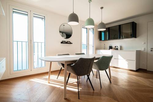 uma cozinha e sala de jantar com mesa e cadeiras em Unique Gandria 3 by Quokka 360 - luxury two-bedroom apartment with a breathtaking view em Lugano