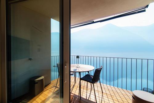 uma varanda com uma mesa e cadeiras. em Unique Gandria 3 by Quokka 360 - luxury two-bedroom apartment with a breathtaking view em Lugano