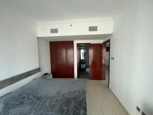 um quarto vazio com uma cama e um corredor em Cozy 1-br apartment in JLT near DMCC Metro em Dubai