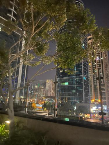 um horizonte da cidade à noite com edifícios altos em Cozy 1-br apartment in JLT near DMCC Metro em Dubai