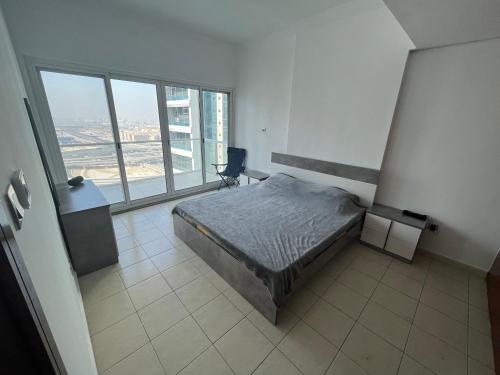 um quarto com uma cama e uma grande janela em Cozy 1-br apartment in JLT near DMCC Metro em Dubai