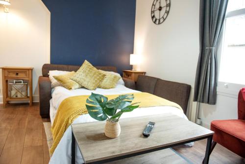a bedroom with a bed and a table with a plant on it at Trinity, Central Cambridge Flat in Cambridge