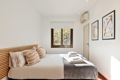 um quarto branco com uma cama grande e uma janela em Enjoy Apartments Urban Retreat Valencia 2 em Barcelona