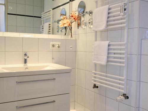 bagno bianco con lavandino e specchio di Strandnahe Ferienwohnung, Zentral gelegen, Ost-Balkon, Andreas Dirks-Str. 2 a Westerland