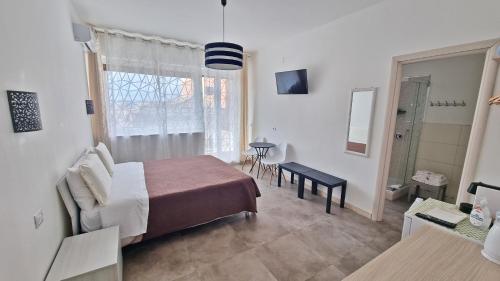 a bedroom with a bed and a chair and a window at MERIDIAN B&B in Siracusa