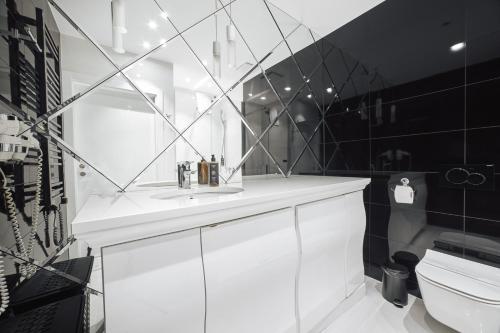 een badkamer met een witte wastafel en een spiegel bij Apartament B225 - Dune Beach Resort in Mielno