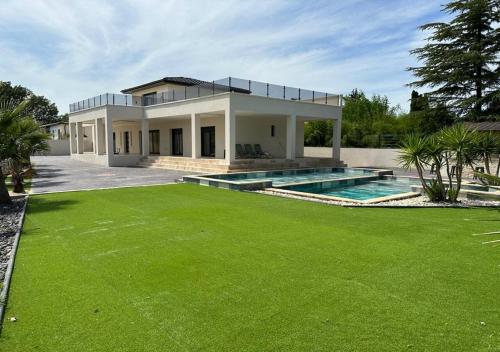 une maison avec une piscine et une pelouse dans l'établissement Villa contemporaine près des gorges de l’Ardèche, à Pont-Saint-Esprit