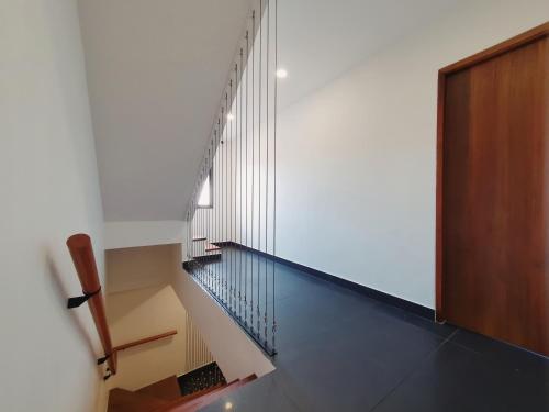 Una escalera en una casa con puerta de madera en The Sila Suites - Intrawarorot, en Chiang Mai