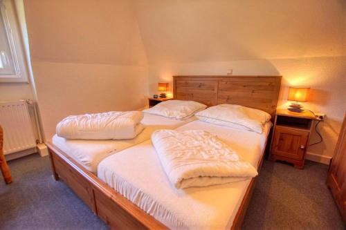 2 Einzelbetten in einem Zimmer mit 2 Lampen in der Unterkunft Ferienhaus Vogelberg, 8VGB06 in Heiligenhafen