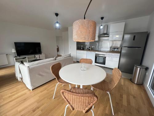 une cuisine et une salle à manger avec une table et des chaises dans l'établissement appartement 4 pièces spacieux grande terrasse, à Clichy