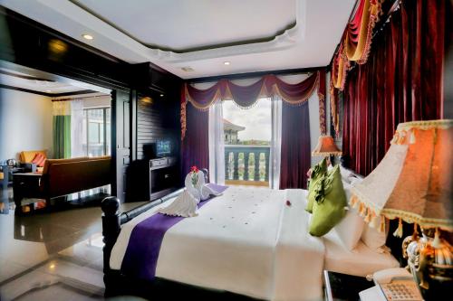 a bedroom with a large bed and a balcony at Lucky Angkor Hotel & Spa in Siem Reap