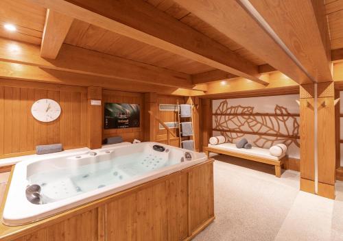 uma banheira de hidromassagem num quarto com paredes de madeira em Les Peupliers em Courchevel