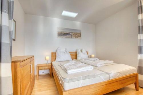 una camera con letto e lenzuola bianche di Ferienpark - Haus A, App 0A0704 a Heiligenhafen