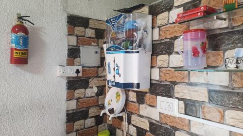 a wall with a brick wall with a refrigerator at Sahara Family Homestay in Mysore