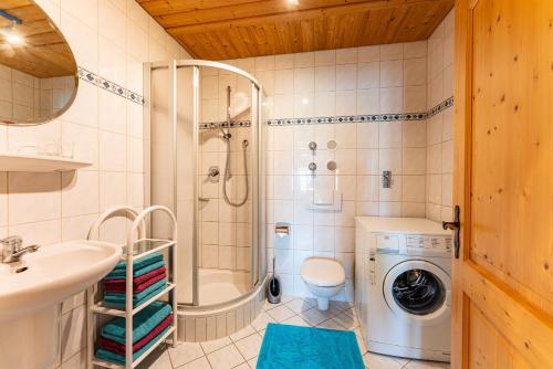 a bathroom with a shower sink and a washing machine at Beim Peterschmied in Eggstätt