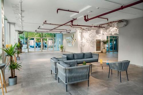 a lobby with couches and chairs in a building at Emirates Sports Hotel, Dubai Sports City in Dubai