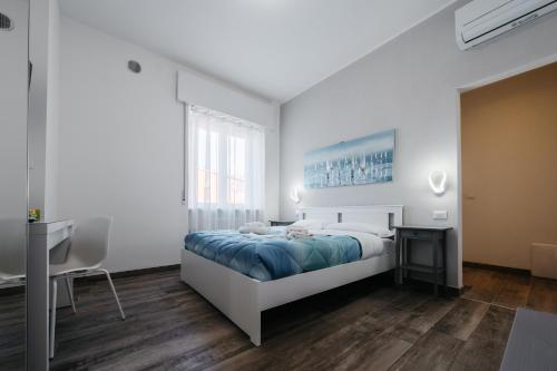维罗纳Porta Nuova Suites的一间带床和书桌的白色卧室