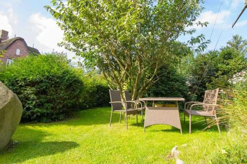 d'un jardin avec des chaises et une table dans la pelouse. dans l'établissement Knurrhahn, Wohnung EG, Dengler, à Utersum