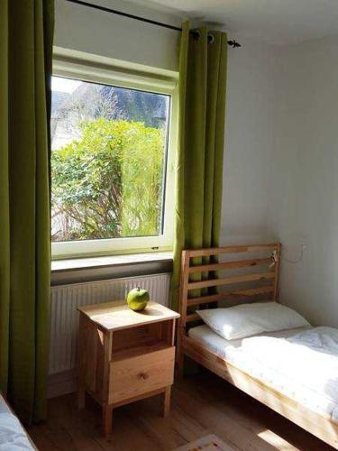 a bedroom with a window and a table with a fruit on it at Knurrhahn, Wohnung EG, Dengler in Utersum