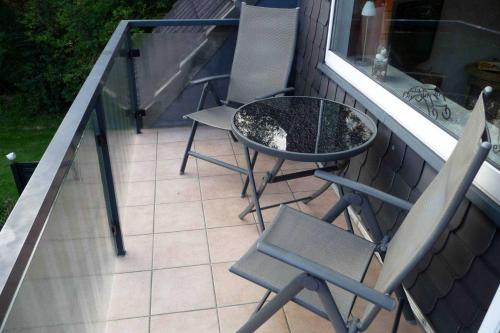 un patio con due sedie e un tavolo su un balcone di Haus Severin Whg Rother mit Balkon Nr 4 a Goting