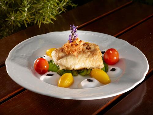a plate of food with fish and vegetables on a table at Hotel Restaurant Lüdenbach in Overath