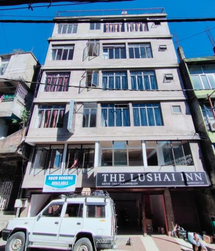 a white suv parked in front of a building at THE LUSHAI INN in Āīzawl