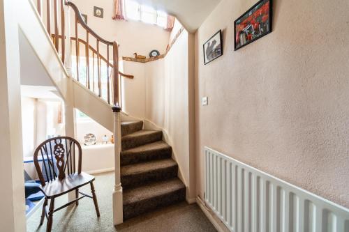 a staircase in a home with a chair and a stair case at Yallands Farmhouse in Taunton